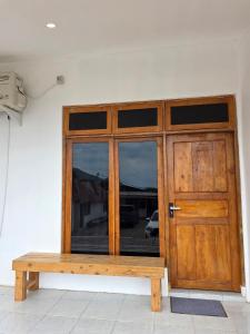 a wooden door with a wooden bench in front of it at Apartamentos de Metiaut in Dili +6 photos