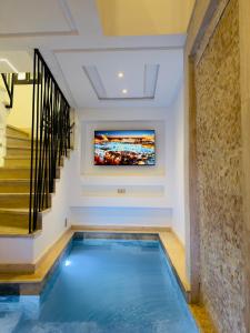 a swimming pool in a house with a tv on the wall at RIAD El Ma in Marrakesh