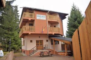 a building with a picnic table in front of it at Pensiunea Patru Brazi in Muntele Cacovei +5 photos