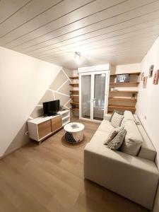 a living room with a couch and a tv at L' Escapade Pannessac premier étage in Le Puy-en-Velay