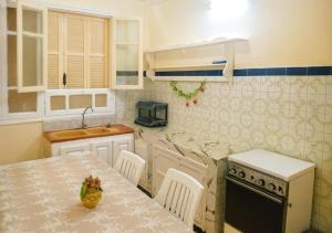 a kitchen with a table and a sink and a stove at Chez Naceur Suite in Tozeur