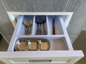 a white drawer with some utensils in it at TN House in Pai