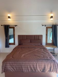 a large bed in a bedroom with two windows at TN House in Pai