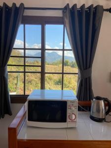 a microwave sitting on a table in front of a window at TN House in Pai