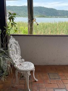 a white chair sitting in front of a window at Incanto in Niterói
