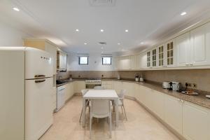 a kitchen with a table and a white refrigerator at Palm Jumeirah - Property Advisers in Dubai