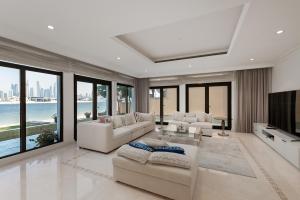 a living room with white furniture and large windows at Palm Jumeirah - Property Advisers in Dubai