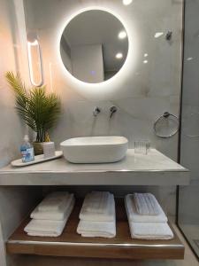 a bathroom with a sink and a mirror and towels at CONSTA Luxury House in Mantamádos +29 photos