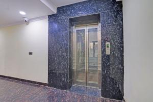 a wall with a glass door in a building at FabHotel Havenora - Nr Maharani Bagh in New Delhi