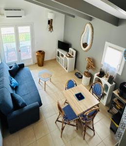 a living room with a blue couch and a table at Un cocon en Camargue in Saintes-Maries-de-la-Mer