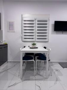 a white table and chairs in a room with a window at Casa Elia AXD in Alexandroupoli