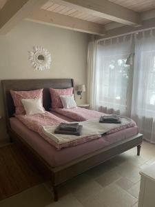 a bedroom with a bed with pink sheets and a window at FeWo Naturgeflüster - Mecklenburger Outback - Garten & Kamin - Private Sauna in Zölkow