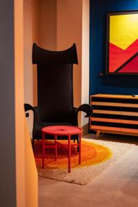 a black chair with a red table in a room at Boutique Hotel Trieste - Adults Only in Verona