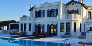 a large white house with a pool in front of it at Mikamas Villas in Pyrgi Thermis