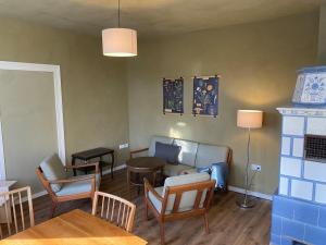 ein Wohnzimmer mit Sofa, Tisch und Stühlen in der Unterkunft Webstube in Drochtersen