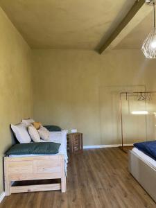 ein Schlafzimmer mit einem Bett und einem Holzboden in der Unterkunft Webstube in Drochtersen