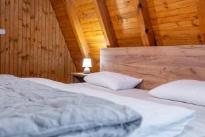 two beds in a room with wooden walls at Kozara Resort in Gornji Podgradci +43 photos