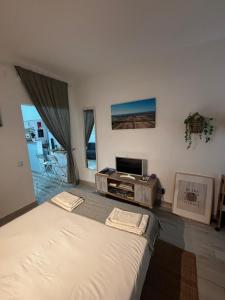 a bedroom with a large bed and a tv at Herdade dos Salgados do Fialho in Faro
