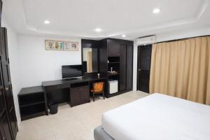 a bedroom with a bed and a desk with a television at Hill Side Patong in Patong Beach