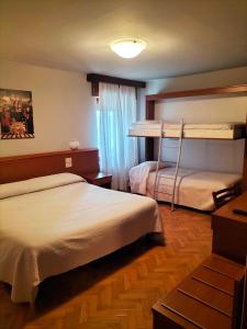 two beds in a room with two bunk beds at Hotel Monte Fior in Foza