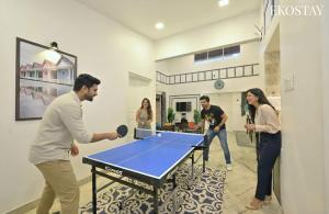 a group of people standing around a ping pong table at EKOSTAY - Pinewood Villa in Alibaug