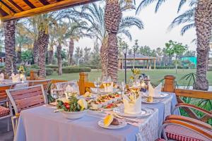 Ein für eine Party gedeckter Tisch, im Hintergrund Palmen. in der Unterkunft Royal Wings Hotel in Lara