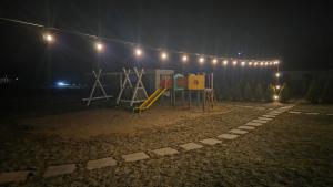 a playground at night with lights on a building at Domek Jozef z prywatnym duzym Jacuzzi i sauna Przystan pod niebem in Łęzyce