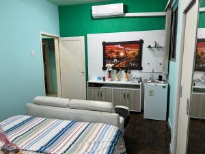 a room with a bed and a kitchen with a sink at Lindo nascer do Sol II in Recife