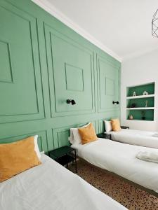 two beds in a room with green walls at Cosy Room 8 in Tal-Pietà