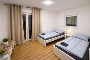 a bedroom with two beds and a table at Platzreiches Apartment an der Mosel in Koblenz-Güls in Koblenz