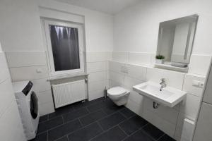 a white bathroom with a toilet and a sink at Platzreiches Apartment an der Mosel in Koblenz-Güls in Koblenz