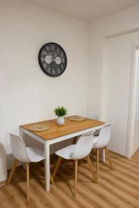 a dining room table with chairs and a clock on the wall at Platzreiches Apartment an der Mosel in Koblenz-Güls in Koblenz