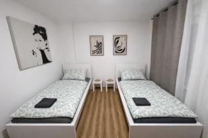a room with two beds and a table at Platzreiches Apartment an der Mosel in Koblenz-Güls in Koblenz