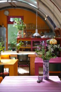 a vase with flowers on a table in a restaurant at Eco Camping De Helleborus in Groningen