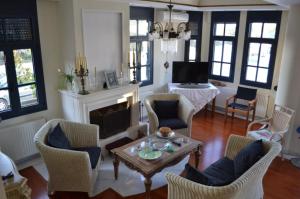 a living room with chairs and a table and a fireplace at Mikamas Villas in Pyrgi Thermis