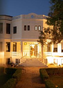 a large white building with stairs in front of it at Mikamas Villas in Pyrgi Thermis