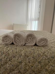 a pile of towels sitting on top of a bed at Apartman Burinović in Temerin