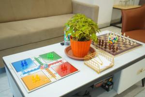 a table with a chess board and a potted plant at Hotel Anugya in Indore