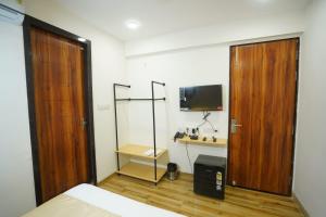 a room with a bed and a wooden door at Hotel Anugya in Indore