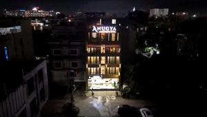 a building with aania sign on top of it at night at Hotel Anugya in Indore