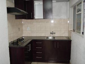 a kitchen with brown cabinets and a sink and a window at Daeka Guesthouse in Kempton Park +30 photos