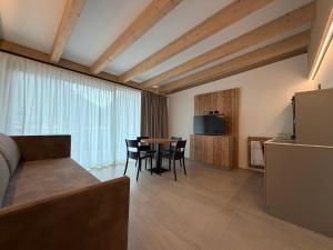 a room with a bed and a table with chairs at Liz Hotel & Apartments in Predazzo +77 photos