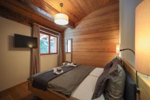 a bedroom with a bed in a room with wooden walls at PRIVÀ Alpine Lodge in Lenzerheide +29 photos