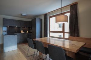 a kitchen and dining room with a wooden table and chairs at PRIVÀ Alpine Lodge in Lenzerheide