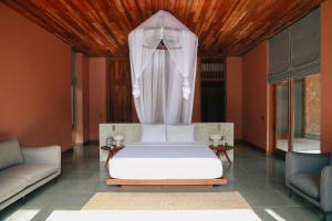 a bedroom with a white bed with a canopy at Kizikula - Boutique Hotel in Kizimkazi