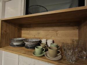 a wooden shelf with cups and plates and glasses at Φεγγαρόπετρα-Ημισέληνος in Kalívia +21 photos