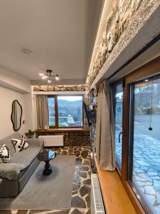 a living room with a couch and a large window at Φεγγαρόπετρα-Ημισέληνος in Kalívia