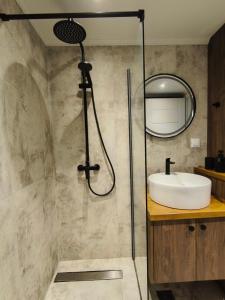 a bathroom with a shower with a sink and a mirror at Φεγγαρόπετρα-Ημισέληνος in Kalívia