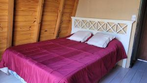 a purple bed with two pillows on top of it at Cabañas Sacha Huasi in Travesía