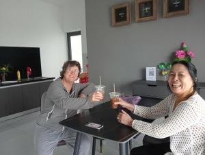 a man and woman sitting at a table with drinks at Canh Tien Homestay Tam Thanh Beach in Tam Kỳ +56 photos